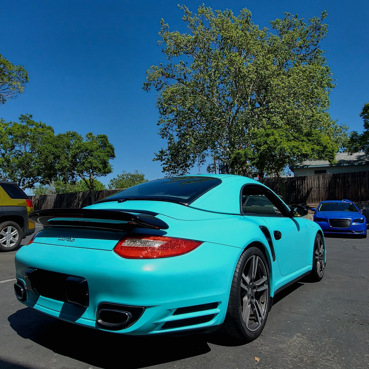 Turquoise Porsche in an outdoor lot
